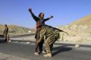 An Afghan National Army soldier (ANA) inspects passengers at a checkpoint on the outskirts of Jalalabad