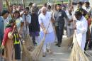 India's Prime Minister Narendra Modi cleans a road