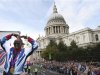 Long distance runner Mo Farah makes his trademark "Mobot" pose outside St Paul's Cathedral during a parade for British Olympic and Paralympic athletes in London