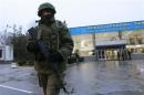 An armed man patrols at the airport in Simferopol