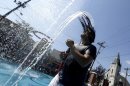 Javier Soler, 20, of West New York, N.J., flips his head back as water from a fountain runs off his hair during a heat wave, Thursday, July 18, 2013, in Union City, N.J. (AP Photo/Julio Cortez)