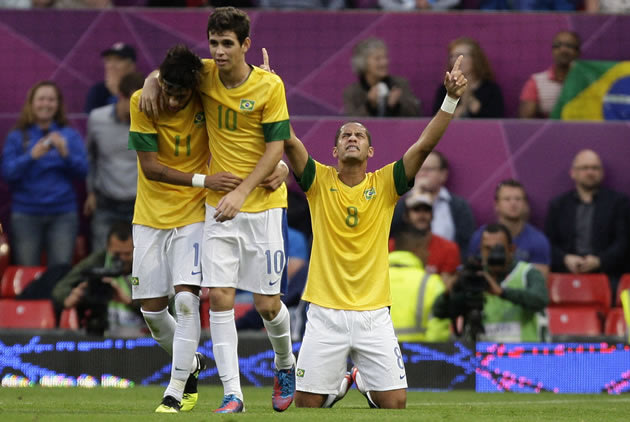 Neymar e Oscar se abraçam enquanto Rômulo comemora seu gol, o primeiro do Brasil (AP Photo)