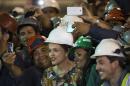 Brazil's President Dilma Rousseff poses for photos with subway construction workers as she visits the site of a new line being built in the Barra da Tijuca neighborhood of Rio de Janeiro, Brazil, Tuesday, May 12, 2015. (AP Photo/Felipe Dana)