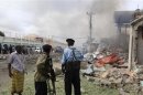 Soldiers watch from a distance the scene of an explosion in Mogadishu