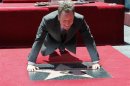 Bryan Cranston does a push-up during ceremonies unveiling his star on the Hollywood Walk of Fame