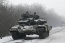 An Ukrainian armored vehicles drive on the road between the towns of Debaltseve and Artemivsk, Ukraine, Monday, Feb. 16, 2015. The Ukrainian government and Russia-backed rebels accused each other Monday of violating a cease-fire in eastern Ukraine, a day before the parties are due to start withdrawing heavy weaponry under a recently brokered deal. The cease-fire, which went into effect on Sunday, had raised cautious hopes for an end to the 10-month-old conflict, which has already claimed more than 5,300 lives. (AP Photo/Petr David Josek)