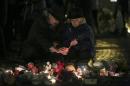 People light a candle as they arrive at Dvortsovaya Square to commemorate victims of the air crash in Egypt in St. Petersburg