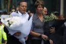 Australian Prime Minister Tony Abbott and his wife Margie prepare to place floral tributes near the cafe in central Sydney where hostages were held for over 16-hours