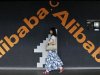 An employee walks past a wall painted with logo of Alibaba (China) Technology Co. Ltd at its headquarters office on the outskirts of Hangzhou