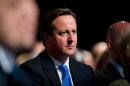 British Prime Minister David Cameron listens to a speech by London Mayor Boris Johnson at the annual Conservative Party Conference in Manchester, north-west England, on October 1, 2013
