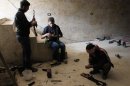 In this Saturday, Nov. 17, 2012 photo, rebels of the Free Syrian Army clean their weapons as airstrikes by the Syrian air force drive the rebels underground, in the northwestern city of Maraat al-Numan, Syria. After months of fierce fighting for control of the vital Aleppo-Damascus highway, the rebels have succeeded in pushing the Syrian army out of the center of Maraat al-Numan located on the highway between Aleppo and Hama. (AP Photo/Mustafa Karali)