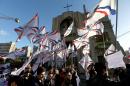 Assyrians wave their community's flag, as they march past a church that was damaged during the Lebanese civil war, during a protest in solidarity with Christians abducted in Syria and Iraq by Islamic State militants, in downtown Beirut, Lebanon, Saturday, Feb. 28, 2015. The Islamic State group, which has repeatedly targeted religious minorities in Syria and Iraq, abducted more than 220 Assyrians this week in northeastern Syria. (AP Photo/Hussein Malla)