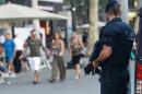 A Catalan policeman (Mossos d'Esquadra) patrols at Plaza Catalunya in Barcelona on June 26, 2015