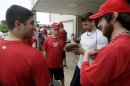 Wounded Warrior Amputee Softball Team members sign a ball glove in Binghamton, New York