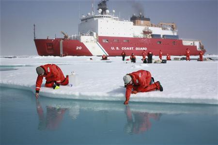 Scientists Jens Ehn (L) and Christie Wood scoop water from melt ponds on sea ice in the Chukchi Sea in the Arctic Ocean in this July 10, 2011 NASA handout photo obtained by Reuters June 10, 2012. REUTERS/Kathryn Hansen/NASA