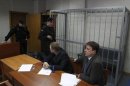 Attorneys of lawyer Sergei Magnitsky sit in front of an empty defendants' cage during a court session in Moscow