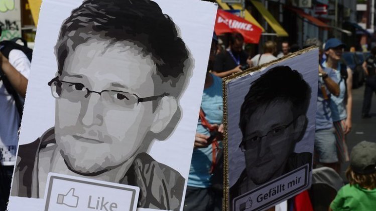 Protesters hold placards bearing the image of former NSA contractor Edward Snowden, in Berlin on July 27, 2013