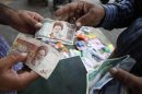 A customer changes Iraqi dinars to Iranian rials at a money changer in Baghdad