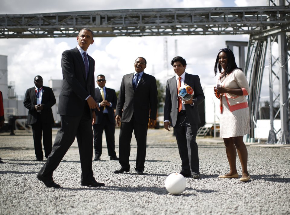 U.S. President Obama points to a soccer ball alongside Tanzania's President Kikwete during a demonstration at Ubungo Power Plant in Dar es Salaam
