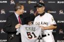 Jeff Idelson, left, president of the National Baseball Hall of Fame and Museum, and Miami Marlins' Ichiro Suzuki smile as Suzuki gives Idelson items from his 3,000 major league hit during a news conference, Monday, Aug. 8, 2016, in Miami. (AP Photo/Wilfredo Lee)