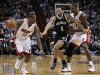 Miami Heat's Mario Chalmers dribbles against Brooklyn Nets' Deron Williams as Heat teammate Chris Bosh looks on in their NBA basketball game in Miami