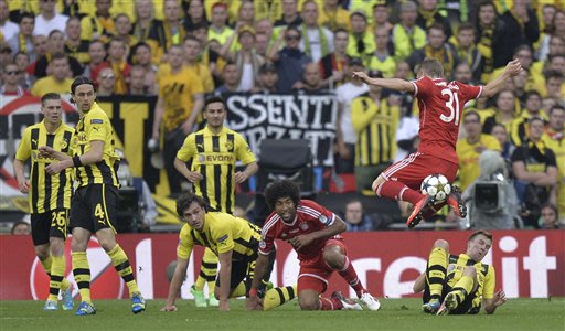 Players watch as Bayern's Bastian Schweinsteiger, right,  jumps with the ball during the Champions League Final soccer match between  Borussia Dortmund and Bayern Munich at Wembley Stadium in London, 