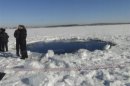 Russian police work near an ice hole at lake Chebarkul, said by the Interior Ministry department for Chelyabinsk to be the point of impact of a meteorite