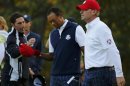 U.S. golfers Woods and Stricker walk past Team Europe captain Olazabal after losing their second match of the day on the 18th green during the afternoon four-ball round at the 39th Ryder Cup golf matches at the Medinah Country Club