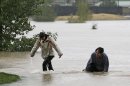 A couple plays in flood water at Utah Park in Aurora, Colo., on Thursday, Sept. 12, 2013. The park was under water due to flooding. Flash flooding in Colorado has cut off access to towns, closed the University of Colorado in Boulder and left at least three people dead.(AP Photo/Ed Andrieski)