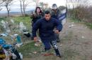 A migrant tries to escape from Macedonian police officers as he tries to cross the Greek-Macedonian border near the Greek village of Idomeni