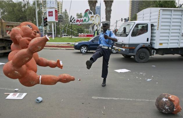 رجل شرطة كيني يركل احد بالونات استخدمت في العاصمة نيروبي بواسطة المتظاهرين هذا الأسبوع