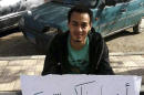 FILE - In this Nov. 25, 2013 file photo provided by a friend of Islam Ateto, engineering student Islam Ateto holds a sign protesting the arrest of fellow students at Ain Shams University, in Cairo, Egypt. Egyptian police are increasingly detaining activists and students in secret, snatching them from homes or the street and holding them for weeks as their families scramble to find them. Activists have tracked well over 100 such disappearances the past two months, a sign of the unchecked power of security agencies in the country. (Photo courtesy of a friend of Islam Ateto, via AP, File)