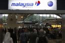 Passengers queue up at the Malaysia Airlines ticketing booth at the Kuala Lumpur International Airport in Sepang