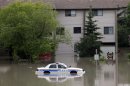 A police car sits stuck in a parking lot of an apartment building after heavy rains have caused flooding, closed roads, and forced evacuation in Calgary, Alberta, Canada Friday, June 21, 2013. (AP Photo/The Canadian Press, Jeff McIntosh)