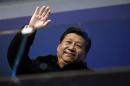 China's President Xi Jinping waves from the presidential tribune at the opening ceremony of the 2014 Winter Olympics