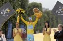 2014 Tour de France cycling race winner Italy's Vincenzo Nibali, wearing the overall leader's yellow jersey, celebrates on the podium in Paris, France, Sunday, July 27, 2014. Left is Paris mayor Anne Hidalgo. (AP Photo/Christophe Ena)