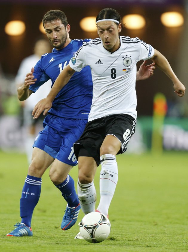 Greece's Fotakis challenges Germany's Oezil during their Euro 2012 quarter-final soccer match at PGE Arena in Gdansk