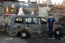 An Iraqi boy inspects a burnt out vehicle the day after a bomb attack in the Sadr City district of Baghdad on September 22, 2103