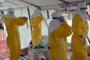 Liberian health workers don full protection outfits at an Ebola treatment center in Monrovia, on October 18, 2014