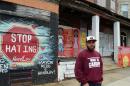 Anthony Dillard, a former drug dealer turned street artist and entrepreneur, poses April 4, 2014 in front of some of his mural paintings in Camden, New Jersey