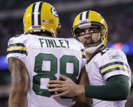 El quarterback Aaron Rodgers, derecha, de los Packers de Green Bay conversa con Jermichael Finley luego de completar con éste un pase de touchdown contra los Giants de Nueva York el domingo 4 de diciembre del 2011. Los Packers son uno de los favoritos para avanzar en la postemporada. (Foto AP/Kathy Willens)