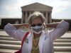 In this photo taken, Monday, June 25, 2012, Carol Paris of Leonardtown, Md. demonstrates outside the Supreme Court in Washington. On Thursday the Supreme Court will deliver their ruling on President Barack Obama's health care package. (AP Photo/Evan Vucci)