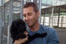 In this Aug. 14, 2013 photo provided by CBS Entertainment, Animal expert Brandon Mcmillan, host and animal trainer of the show "Lucky Dog" picks up a dog at an animal shelter. McMillan swoops into animal shelters across the U.S., rescuing untrained and unadoptable dogs. Then, back at his training facility known as the Lucky Dog Ranch, he trains them for a lucky family to adopt them. Mcmillan will rescue, train and place 22 dogs in 22 weeks for CBS's 'Lucky Dog," which airs Saturday, at 9:30 a.m. EDT. (AP Photo/Bryan Curb, CBS Entertainment)