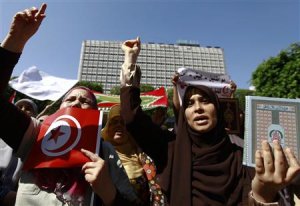 Women shout slogans and hold a copy of the Koran during …