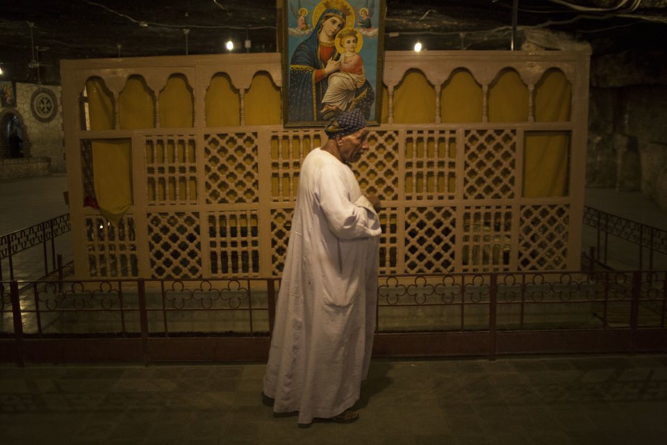 An Egyptian Coptic walks beside the altarpiece within a cave at Al-Mahraq monastery in Assiut, Upper Egypt, Tuesday, Aug. 6, 2013. Islamists may be on the defensive in Cairo, but in Egypt's deep south they still have much sway and audacity: over the past week, they have stepped up a hate campaign against the area's Christians. Blaming the broader Coptic community for the July 3, 2013 coup that removed Islamist President Mohammed Morsi, Islamists have marked Christian homes, stores and churches with crosses and threatening graffiti. (AP Photo/Manu Brabo)