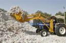 An employee loads cotton onto a truck at a cotton processing unit on the outskirts of the western