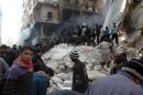 Syrians search for survivors amidst the rubble following an airstrike in the Shaar neighborhood of Aleppo on December 17, 2013