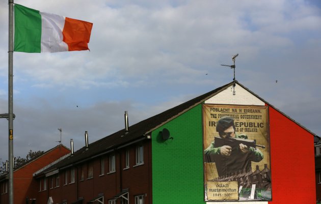 An Irish flag flies beside a mural in the Ardoyne area of North Belfast. (REUTERS/Cathal McNaughton)