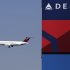 In this Saturday,  April 6, 2013, photo, a Delta Airlines jet flies past the company's billboard at Citi Field, in New York. Delta Air Lines Inc. reports quarterly financial results before the market opens Tuesday, April, 23, 2013. (AP Photo/Mark Lennihan)