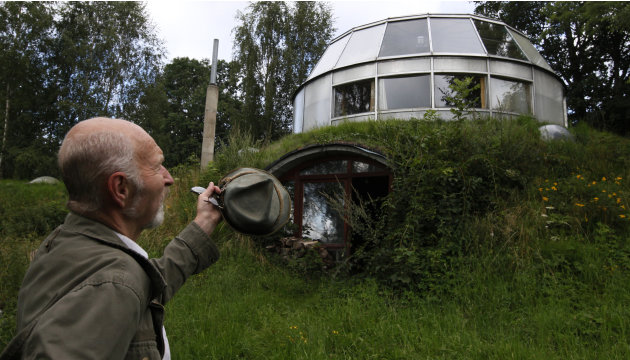 Lhota, a 73-year-old builder, stands in front of the house which he built in Velke Hamry